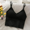 Black off-shoulder camisole tank top laid on a white surface next to yellow roses.