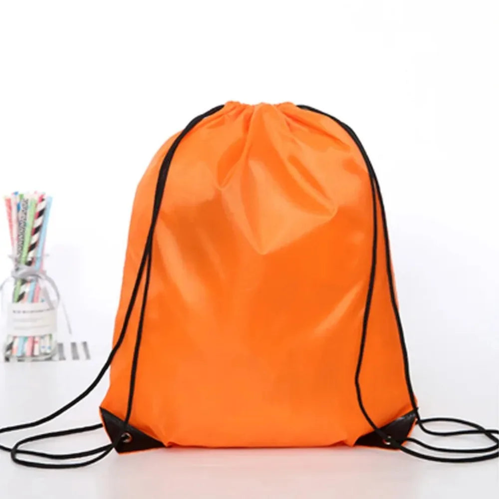 An orange drawstring storage bag with black trim lying on a white surface.