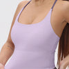 A woman wearing a light purple women's athletic crisscross tank top.
