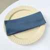 A navy blue elastic hairband is placed on a light beige plate.