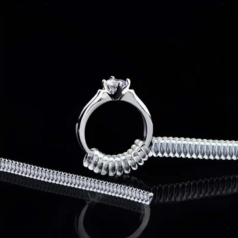 A set of four invisible ring sizer tools including a ring and a diamond ring, displayed on a reflective black surface.