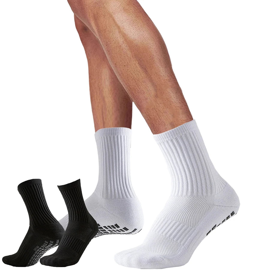 A pair of white athletic grip socks and black compression socks worn on legs.