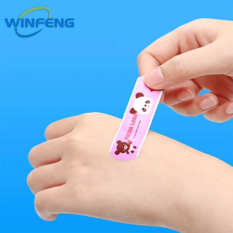 Une main applique un pansement adhésif rose avec un motif panda sur la peau d'une personne.