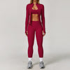 A woman models a three-piece maroon yoga sports set consisting of a cropped top, leggings, and a long-sleeved jacket.