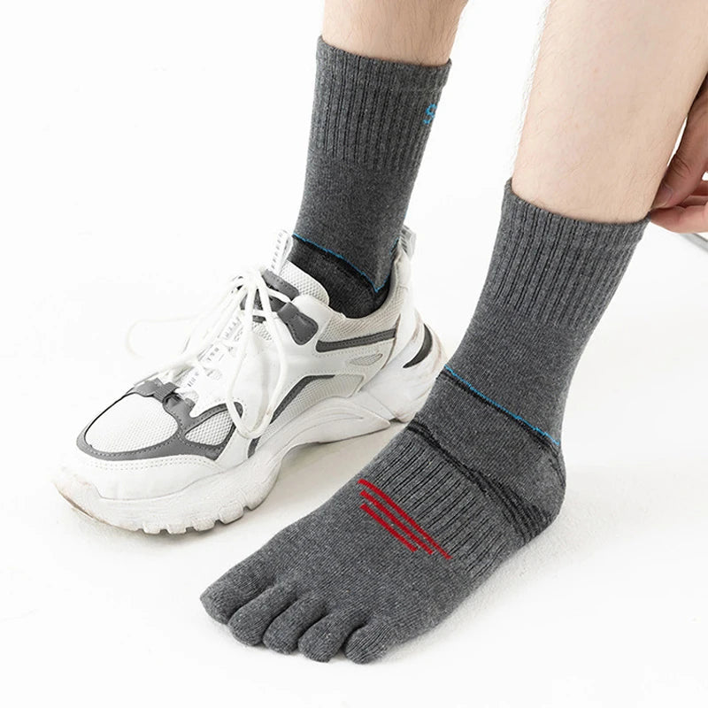 A pair of gray compression socks with white athletic shoes and a red stripe detail.
