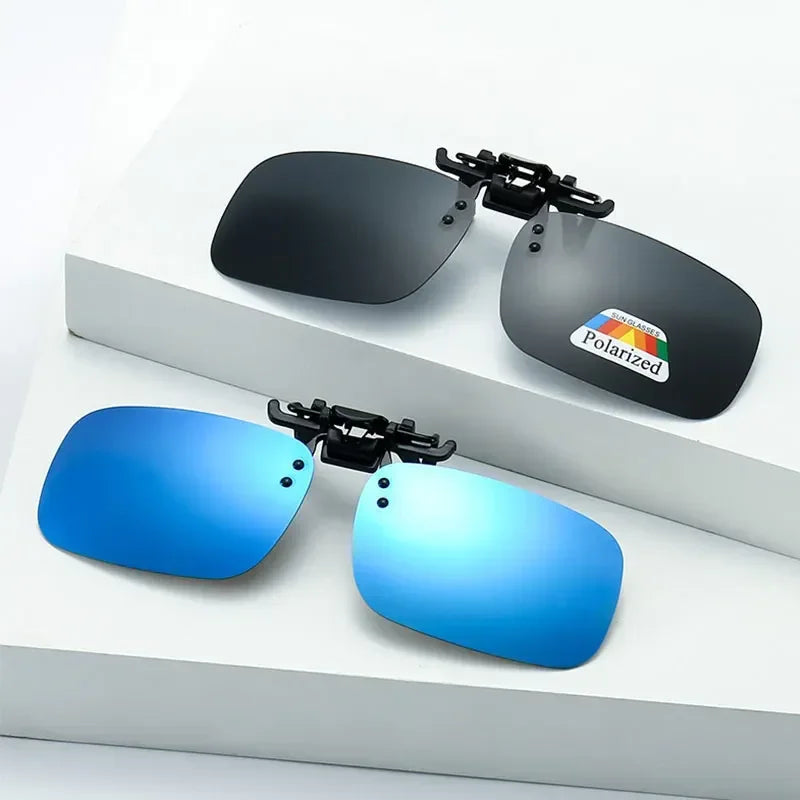 A pair of polarized driving sunglasses with black and blue lenses displayed on a white surface.