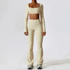 A woman wearing a beige women's performance tracksuit set consisting of a cropped top and matching full-length pants.