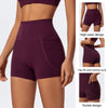 A woman models a deep purple high-waist yoga and workout short featuring a side pocket.