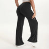 A person is modeling black NCLAGEN SoftMotion straight leg yoga pants with a white top.