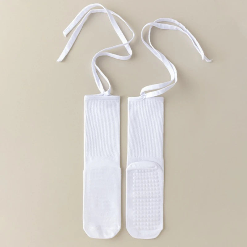 Pair of white silicone anti-slip yoga socks with white ties