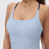 A light blue women's athletic crisscross tank top worn by a model.
