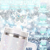 Un capuchon en paille scintillant en forme de papillon sur un tumbler en acier inoxydable.