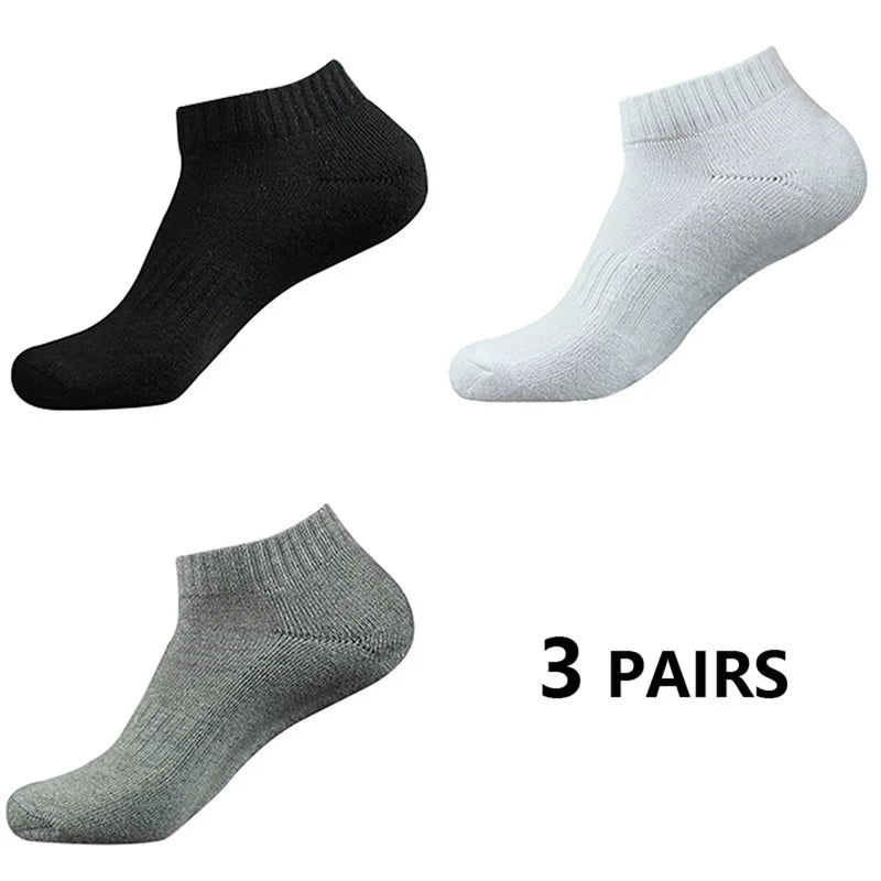 Tres pares de calcetines deportivos de algodón para el tobillo en negro, gris claro y gris medio.