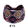 A patterned boho cotton turban headband featuring geometric designs in navy, maroon, and white.