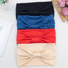 Ein Stapel von vier weichen elastischen breiten Stirnbändern in schwarz, blau, rot und beige.