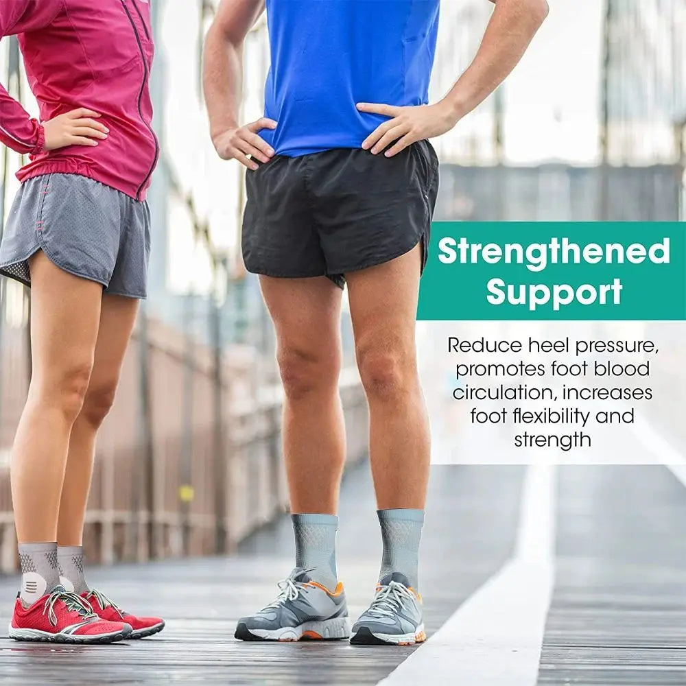 A person wearing black shorts is shown standing on a wooden walkway, demonstrating therapeutic compression socks for foot and