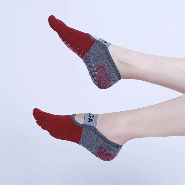 A pair of red and gray breathable silicone yoga and fitness socks worn on a foot.