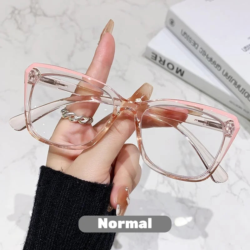 Eine Hand hält eine rosa photochromische multifokale Brille vor einem weißen Marmorhintergrund.