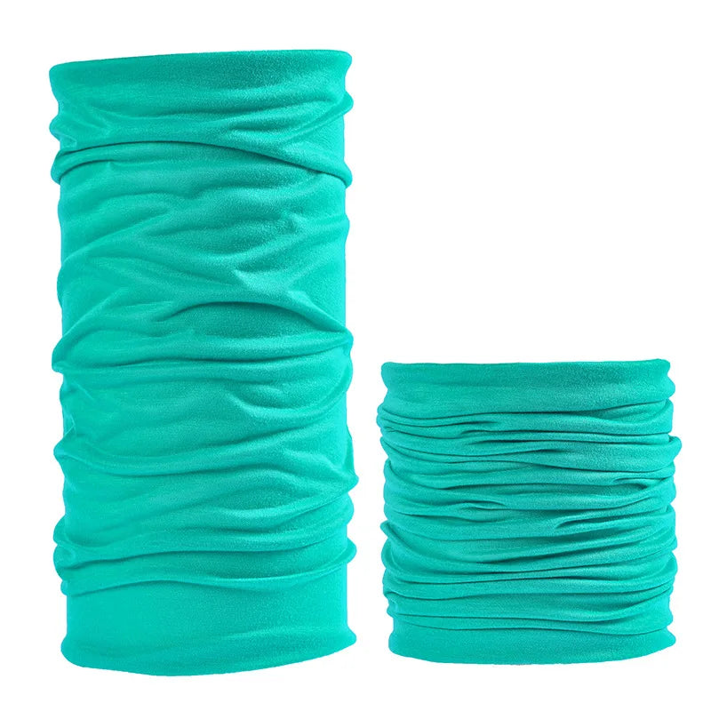 A pair of teal seamless fabric headbands and balaclavas rolled into cylindrical shapes.