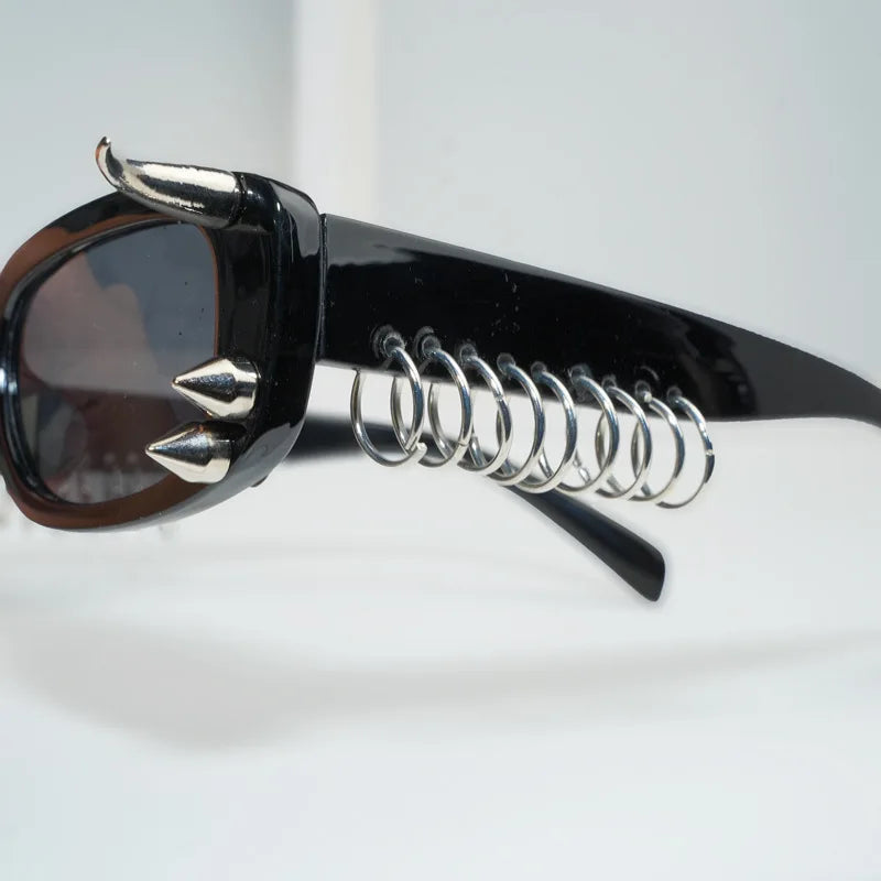 Black sunglasses with spiked rivets and a silver coil detail
