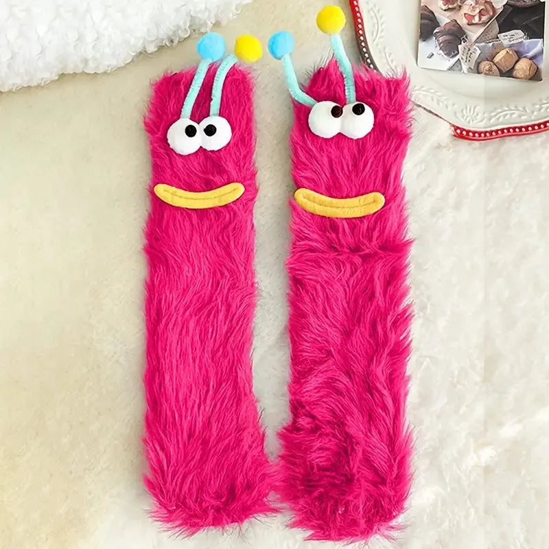 Pair of bright pink fuzzy knit socks with cartoon face designs
