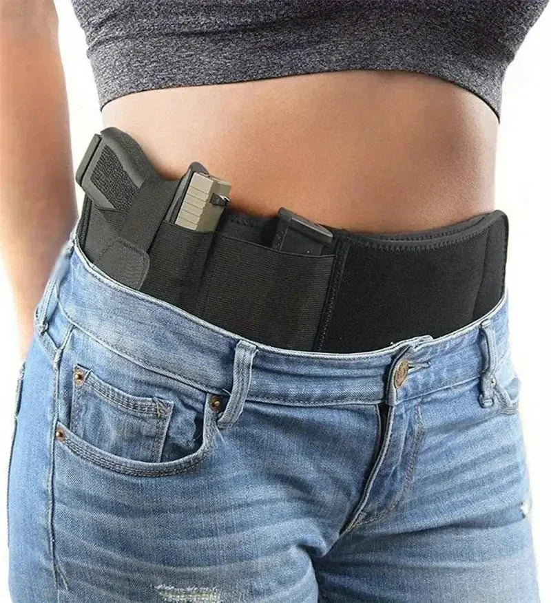 Un ceinture tactique noire est portée autour de la taille d'une personne vêtue de jeans bleus.