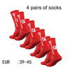 Four pairs of red athletic soccer socks with non-slip grips.