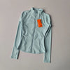 A light blue quick-dry yoga and fitness jacket with a full zip collar is displayed on a plain background.