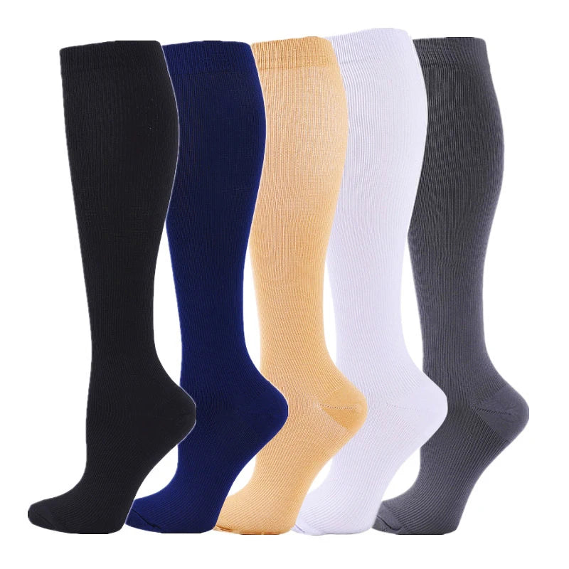 A row of nine medical grade compression socks in various colors including black, navy blue, beige, white, and gray.