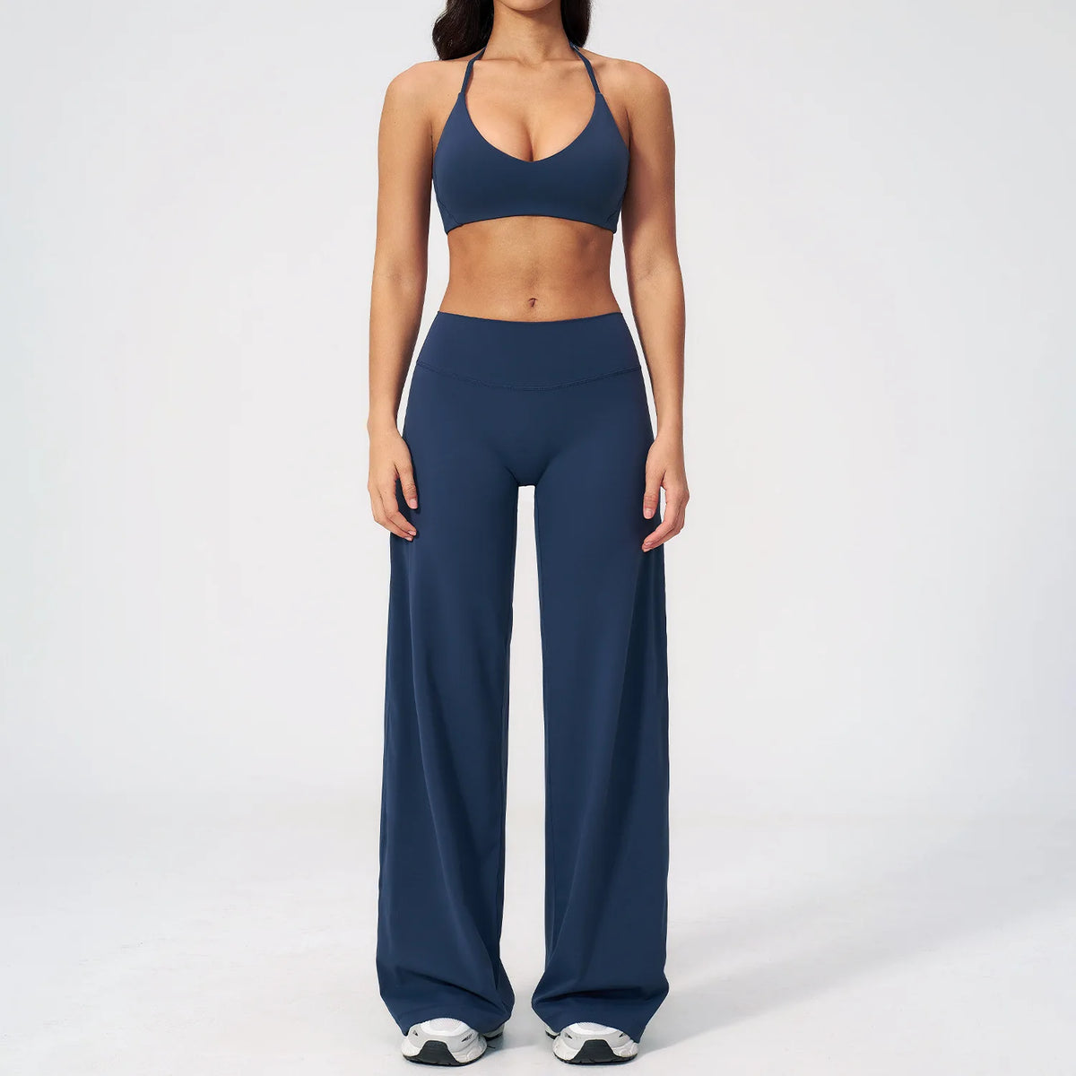 A woman wearing a navy blue women's premium fitness tracksuit top and matching pants.