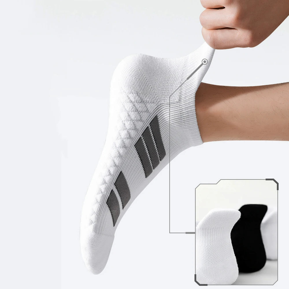 Gros plan d'une chaussette de sport blanche à coupe basse avec des rayures noires sur le pied, en train d'être mise par une m