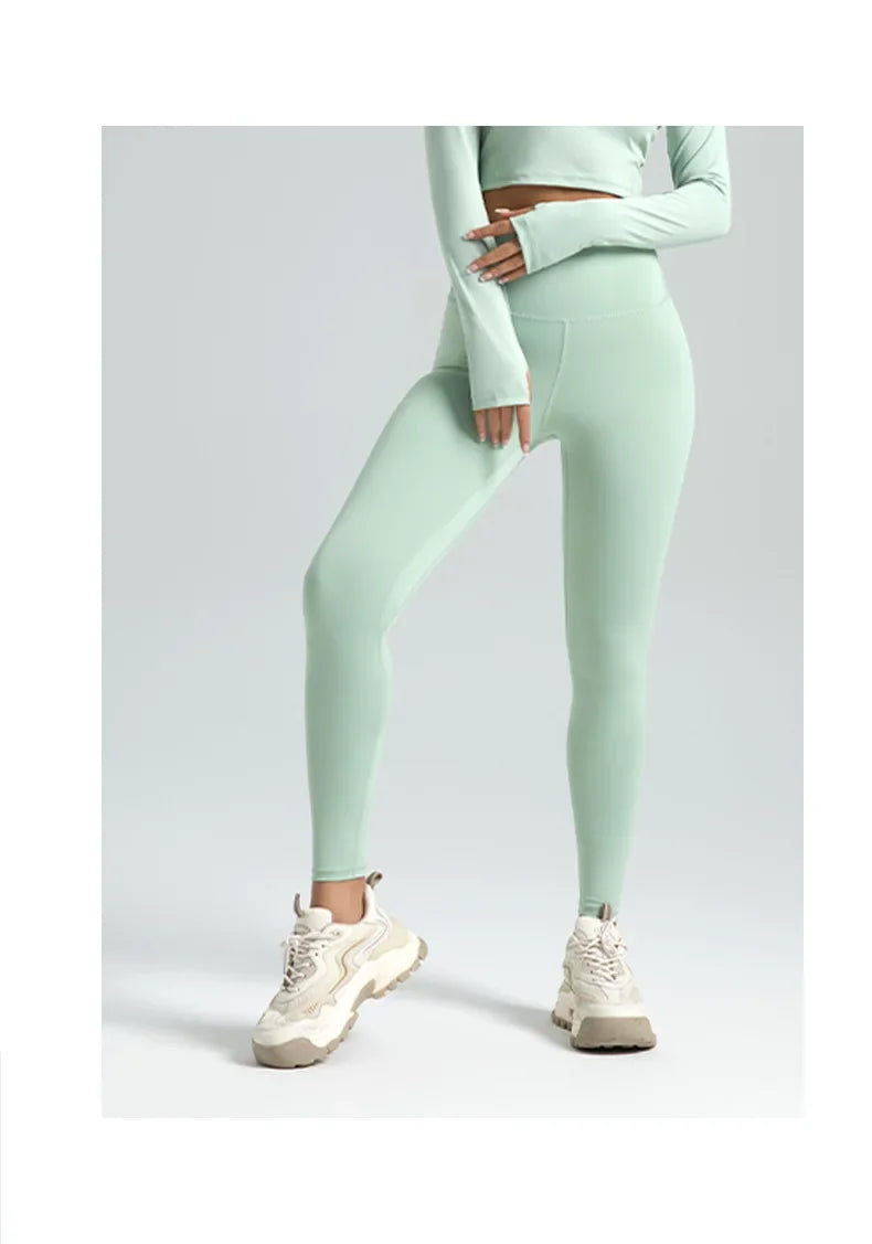 A model wearing light mint green seamless high-waist yoga leggings and a matching cropped top.
