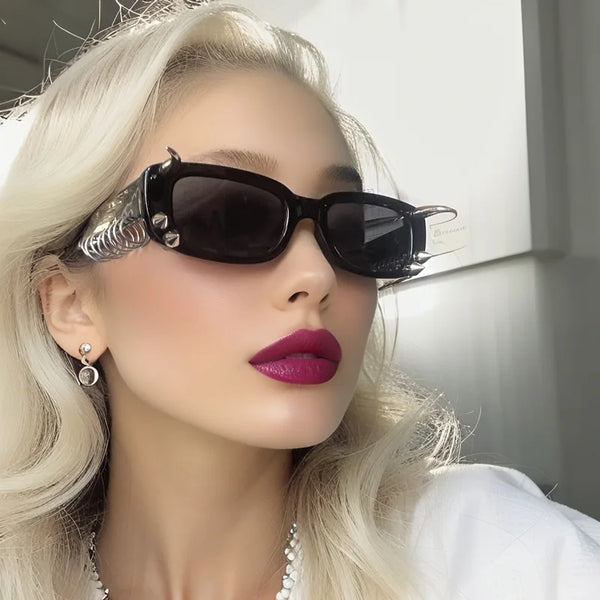 Gros plan d'une femme portant des lunettes à rivets noirs et du rouge à lèvres rose vif.
