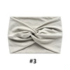 A light gray fabric headband tied in a knot, shown flat lay.