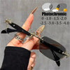 A hand holds a pair of black photochromic prescription glasses with gold accents, demonstrating light tinting capabilities.