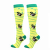 A pair of bright yellow compression elastic socks with green trim and black animal print designs.