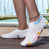 White waterproof quick-dry outdoor hiking shoes worn by a person standing outdoors