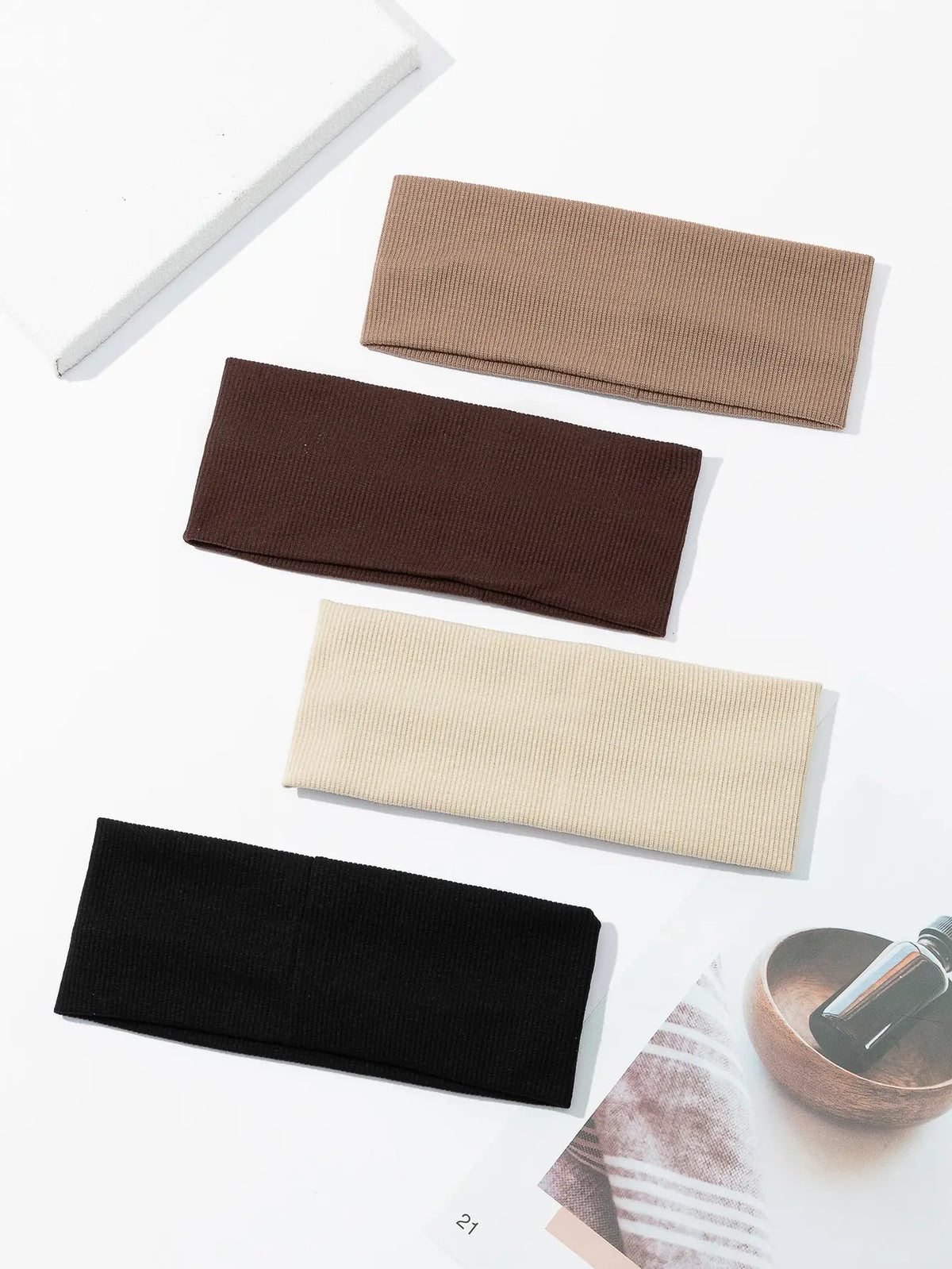 Un paquete de cuatro bandas elásticas para el cabello en marrón, marrón oscuro, beige y negro.