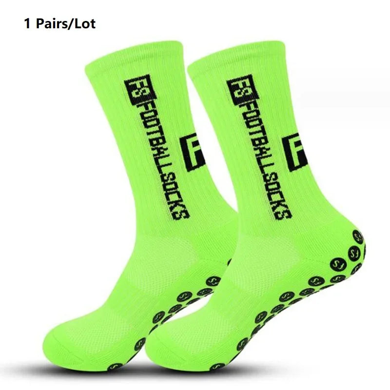 A pair of neon yellow performance sports socks with black grip dots, shown from above.