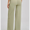 A woman wearing light olive green high-waist flared yoga pants from the back view.