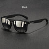 Black vintage designer square sunglasses resting on a dark surface.