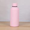 A pink double-layer vacuum thermos cup with a black lid sitting on a wooden surface.