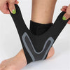 A black ankle support compression sleeve worn on a person's foot and ankle.