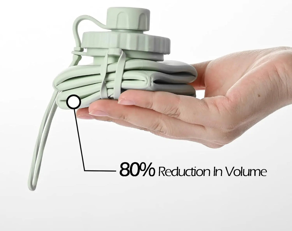 A hand holds a light green collapsible silicone sports water bottle, demonstrating an 80% reduction in volume.