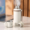 A white 316 stainless steel insulated water bottle with a metal lid and a separate cup resting on a marble surface.