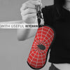 A red spider web patterned eyeglass pouch attached to a keychain, held by a person.