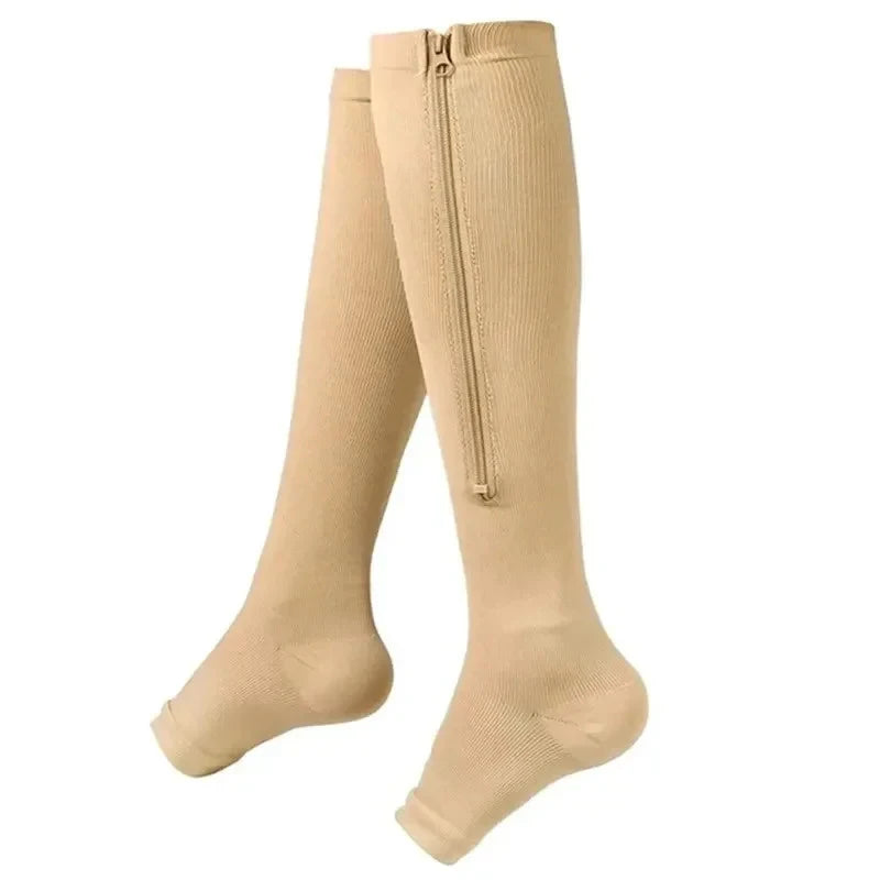 A pair of beige compression stockings with a zipper detail.