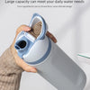 A hand holds a large capacity light blue insulated stainless steel water bottle with a dual drinking spout.