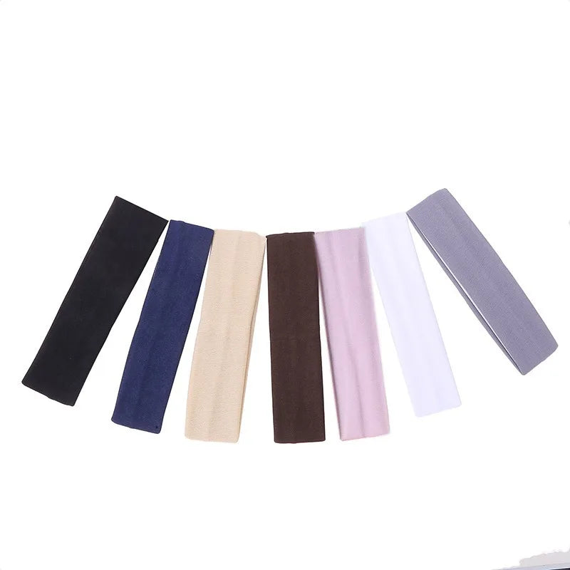 A set of solid elastic hair bands in various shades including black, navy blue, beige, brown, pink, white, and gray.
