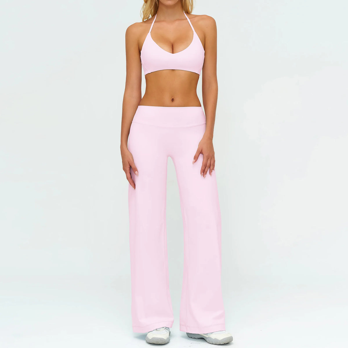 A woman wearing a pink women's premium fitness tracksuit top and matching pants.